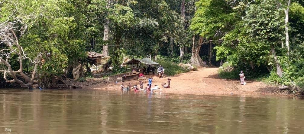 indigenous people on riverbank, children bathing, playing